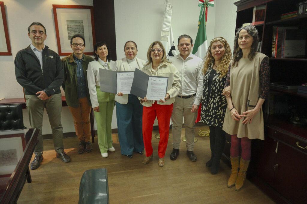 En un recinto en primer plano hay 8 personas, al centro con un documento firmado en las manos, en la izquierda esta la Doctora Yadira Zavala Osorio, Rectora de la UAM Azcapotzalco, a la derecha, la Licenciada Patricia Aguilar López, Representante Legal de Fundación Tatis